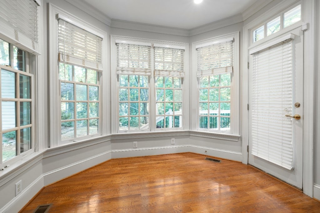 Sunroom with bay windows and warm oak hardwood floors